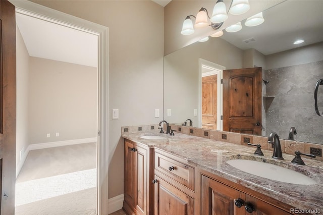 bathroom with visible vents, a sink, baseboards, and double vanity