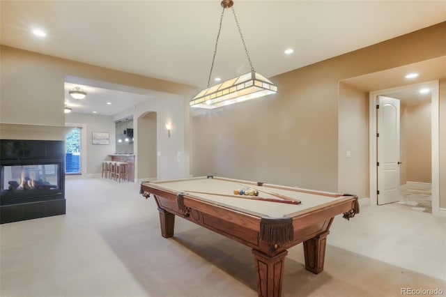 playroom with carpet floors, arched walkways, a multi sided fireplace, and recessed lighting