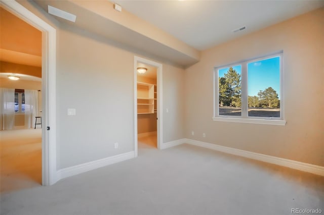 carpeted bedroom with a closet, visible vents, a spacious closet, and baseboards