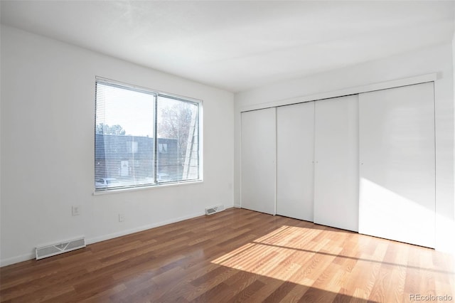 unfurnished bedroom featuring hardwood / wood-style floors and a closet