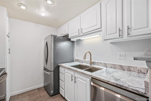 kitchen with light hardwood / wood-style flooring, white cabinetry, sink, and stainless steel appliances