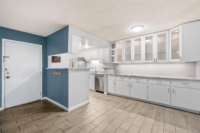 kitchen featuring a textured ceiling, stainless steel appliances, sink, light hardwood / wood-style flooring, and white cabinetry