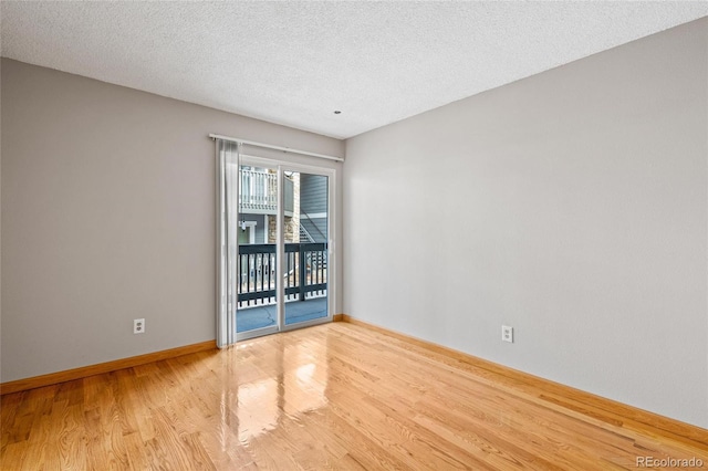 unfurnished room with a textured ceiling and light wood-type flooring