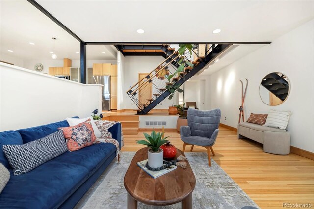 living area with baseboards, recessed lighting, visible vents, light wood-style floors, and stairs