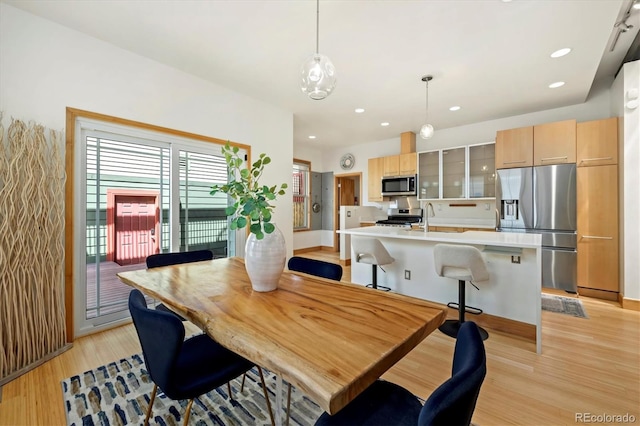 dining area with baseboards, recessed lighting, and light wood-type flooring