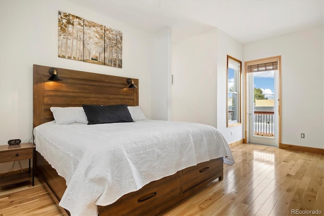 bedroom featuring wood finished floors, baseboards, and access to outside