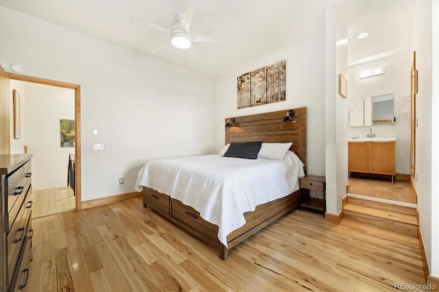 bedroom with a ceiling fan, a sink, connected bathroom, light wood-style floors, and baseboards