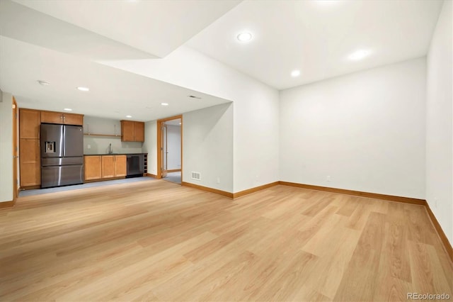 unfurnished living room with light wood finished floors, a sink, baseboards, recessed lighting, and visible vents