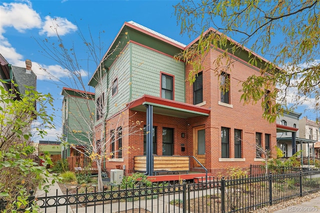 2937 Champa St Unit A, Denver, CO 80205 - italianate-style house featuring a fenced front yard, brick siding, and a porch