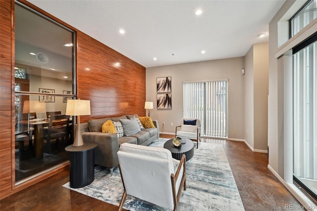 3195 Blake St Unit 106, Denver, CO 80205 - living area featuring finished concrete flooring, baseboards, recessed lighting, and an accent wall