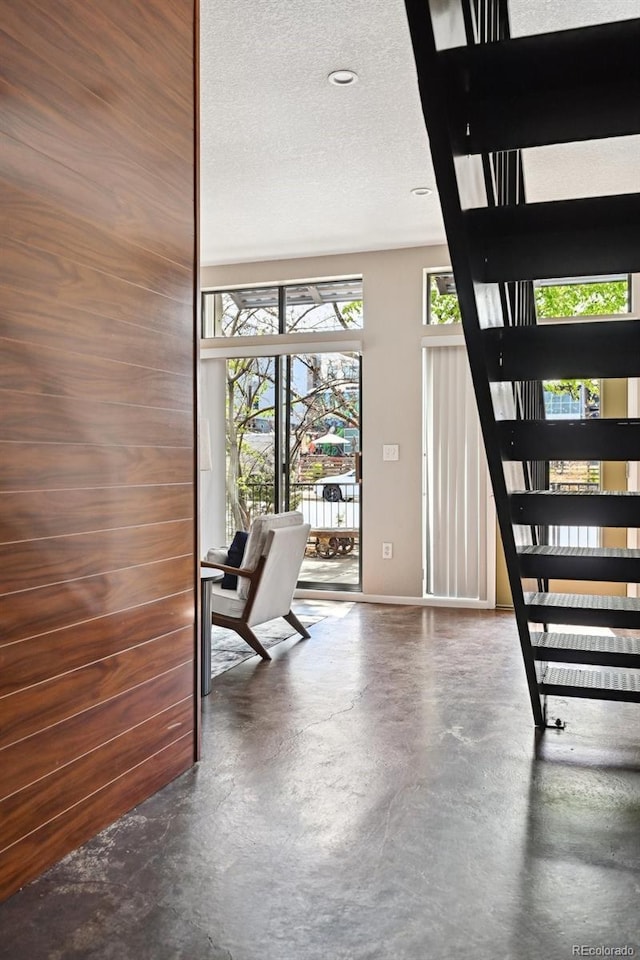 3195 Blake St Unit 106, Denver, CO 80205 - stairway with finished concrete flooring, baseboards, and a textured ceiling
