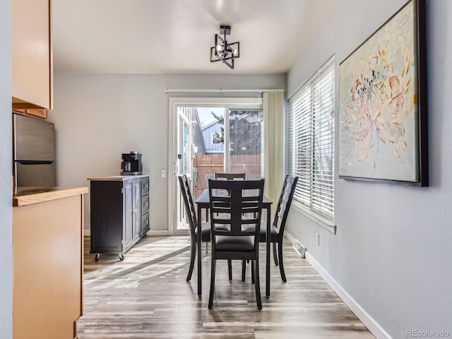 dining room with an inviting chandelier, baseboards, and wood finished floors