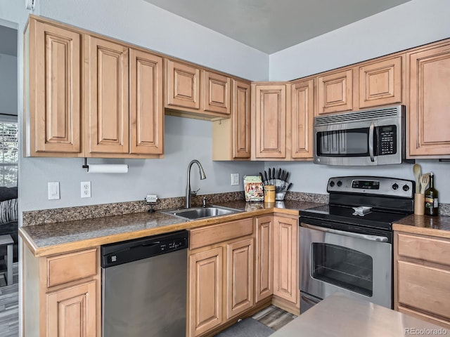 kitchen featuring dark countertops, appliances with stainless steel finishes, and a sink