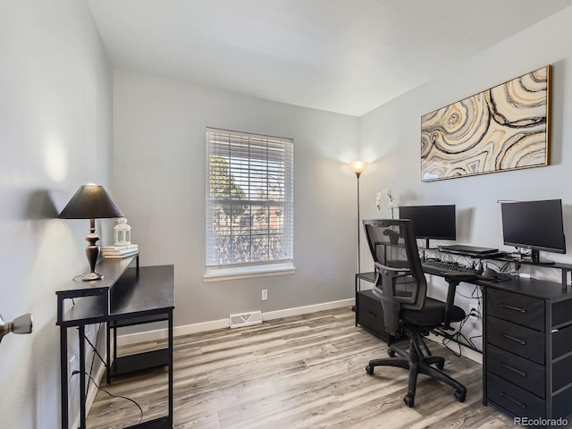 office area featuring baseboards, visible vents, and wood finished floors