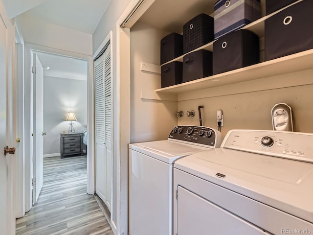 laundry area with light wood-type flooring, laundry area, baseboards, and separate washer and dryer