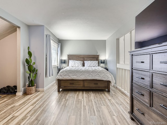 bedroom with light wood-type flooring and baseboards