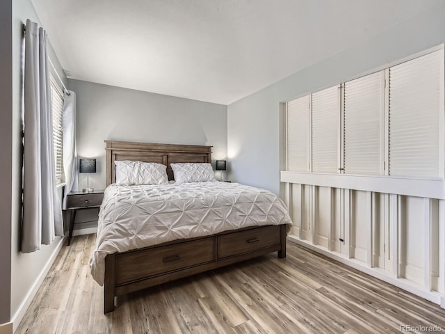 bedroom with baseboards and wood finished floors