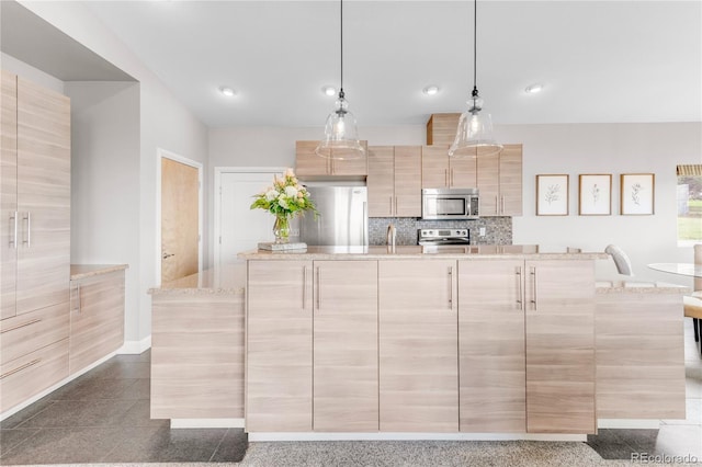 kitchen with light stone counters, light brown cabinets, an island with sink, pendant lighting, and stainless steel appliances