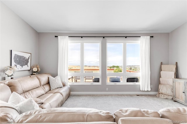 living room with light carpet, a healthy amount of sunlight, and a water view