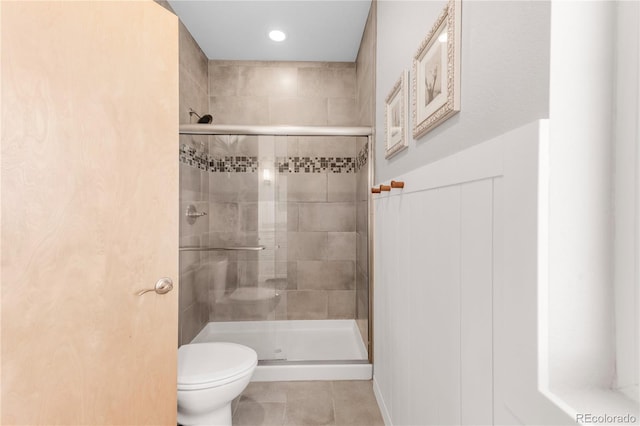 bathroom with a shower with shower door, tile patterned floors, and toilet