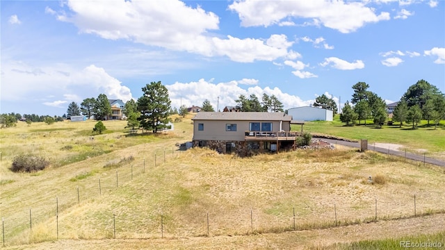 view of front of property with a rural view and a wooden deck