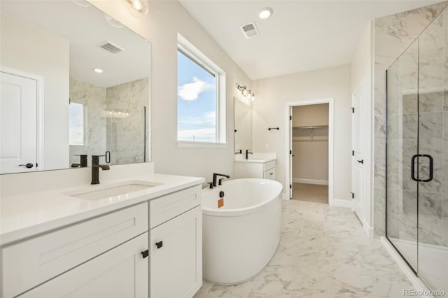 bathroom with vanity and shower with separate bathtub