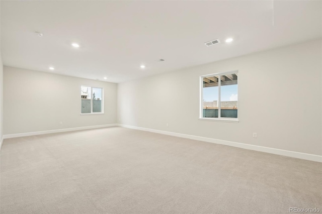 carpeted spare room featuring a healthy amount of sunlight