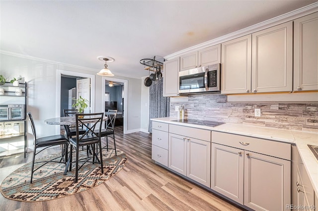 kitchen featuring black electric stovetop, gray cabinets, crown molding, and light hardwood / wood-style flooring