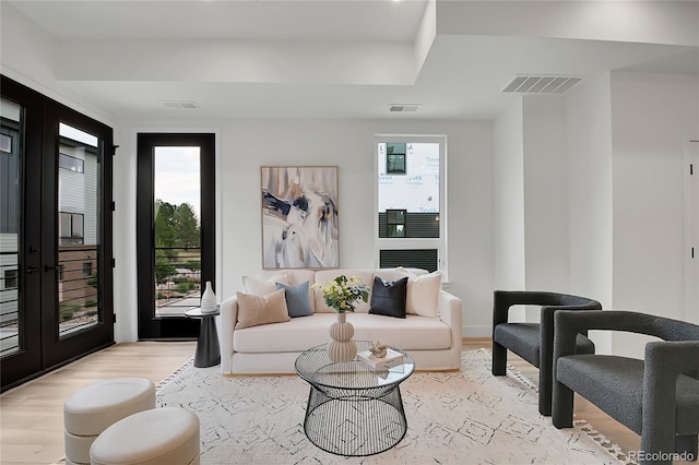 living room with french doors and light wood-type flooring