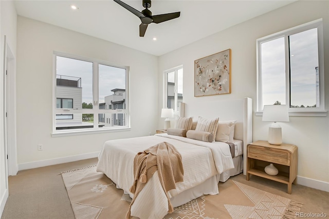 bedroom with multiple windows, light colored carpet, and ceiling fan