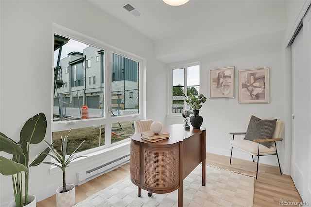 office space featuring baseboard heating and light wood-type flooring