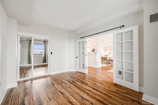 601 W 11th Ave Unit 1101, Denver, CO 80204 - unfurnished bedroom featuring french doors, wood finished floors, and baseboards