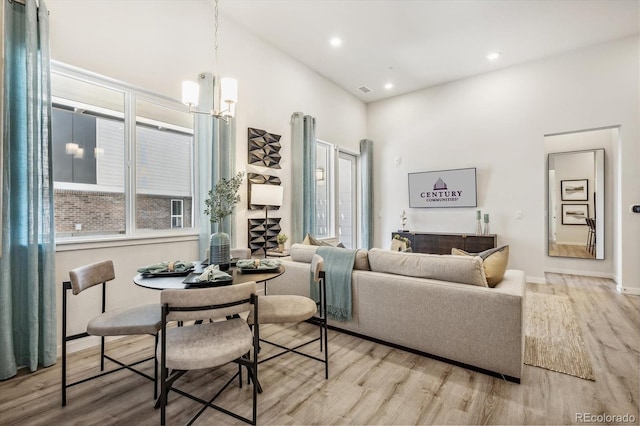 487 Interlocken Blvd Unit 106, Broomfield, CO 80021 - living area with a towering ceiling, wood finished floors, a chandelier, baseboards, and recessed lighting