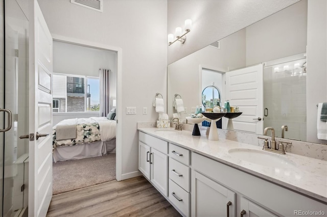 487 Interlocken Blvd Unit 106, Broomfield, CO 80021 - bathroom with double vanity, ensuite bathroom, wood finished floors, a shower stall, and healthy amount of natural light
