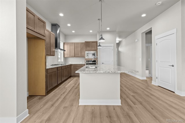 21202 E 63rd Dr, Aurora, CO 80019 - kitchen with an island with sink, wall chimney range hood, light wood-type flooring, recessed lighting, and appliances with stainless steel finishes