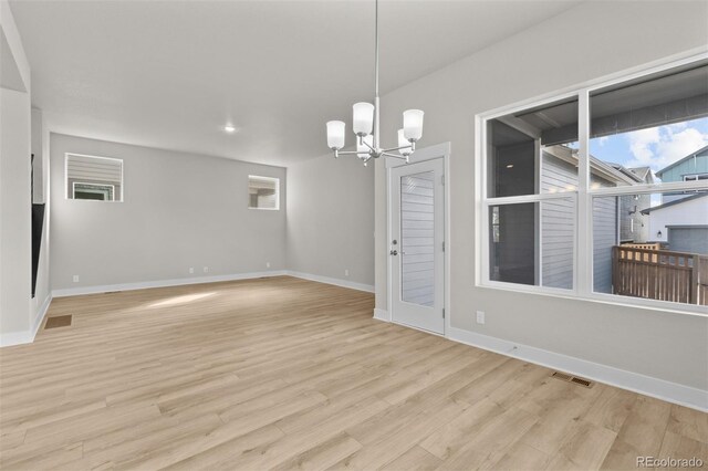 21202 E 63rd Dr, Aurora, CO 80019 - spare room featuring a chandelier, plenty of natural light, light wood-style flooring, baseboards, and visible vents