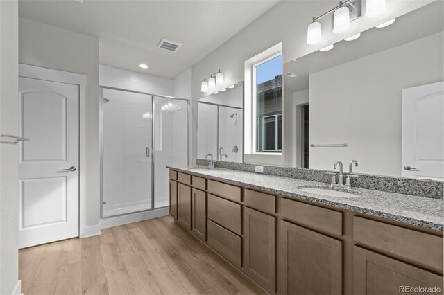 21202 E 63rd Dr, Aurora, CO 80019 - bathroom featuring a sink, a shower stall, wood finished floors, and visible vents