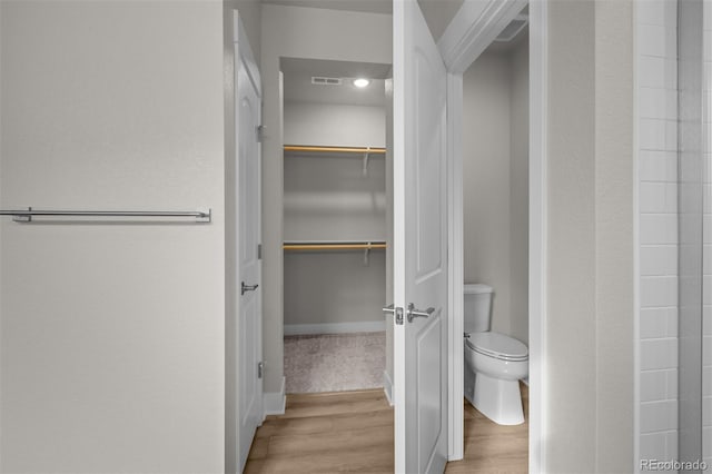 21202 E 63rd Dr, Aurora, CO 80019 - bathroom with visible vents, a walk in closet, wood finished floors, and toilet