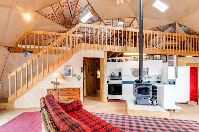 902 Hawk Way, Jefferson, CO 80456 - living room with wooden walls, a wood stove, stairway, and vaulted ceiling