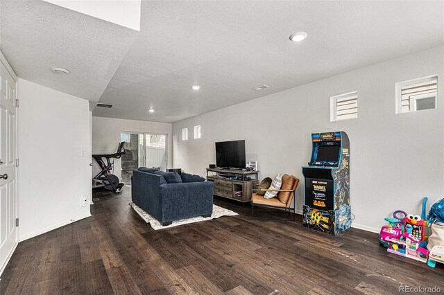 living area with baseboards, wood finished floors, a wealth of natural light, and recessed lighting