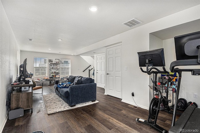 workout area featuring dark wood-style floors, visible vents, and baseboards