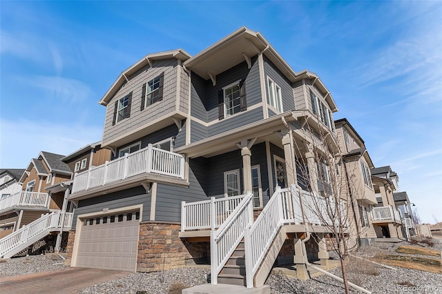 view of front of property featuring a garage, stone siding, driveway, and stairway