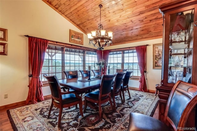 dining room featuring plenty of natural light, a chandelier, hardwood / wood-style flooring, and vaulted ceiling