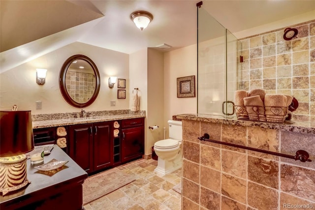 bathroom with a shower with shower door, vanity, tile patterned flooring, and toilet