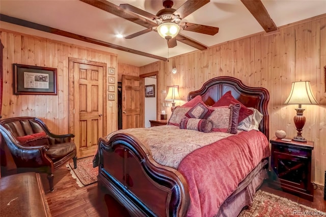 bedroom featuring beam ceiling, wood walls, dark hardwood / wood-style flooring, and ceiling fan