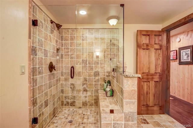 bathroom with a shower with shower door and wood-type flooring