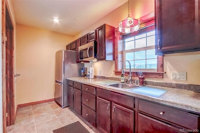 kitchen featuring appliances with stainless steel finishes, decorative light fixtures, light tile patterned floors, and sink