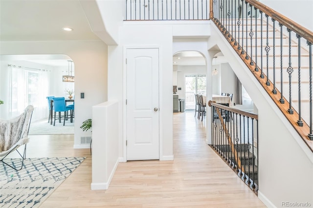 interior space with recessed lighting, visible vents, arched walkways, light wood-style floors, and baseboards
