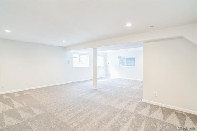 basement featuring baseboards, recessed lighting, and light colored carpet