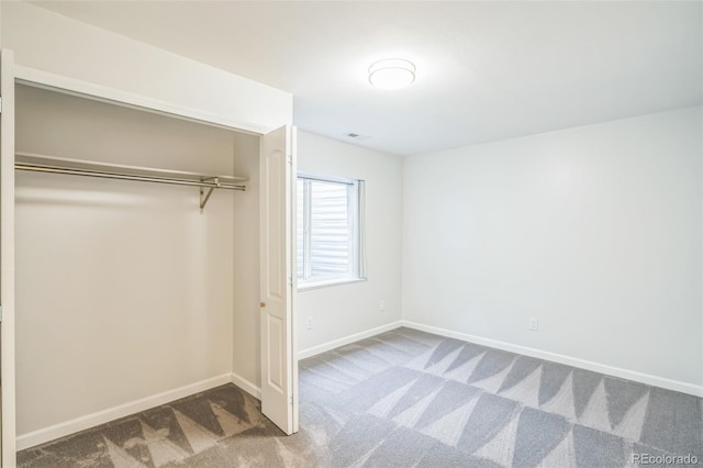 unfurnished bedroom with carpet floors, a closet, and baseboards